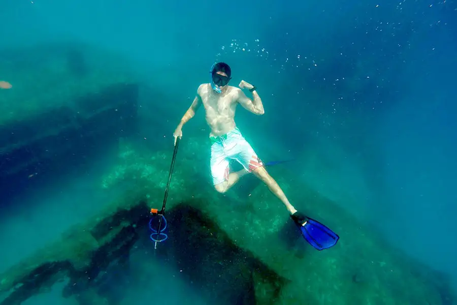 Snorkeler spearfishing near sunken wreck