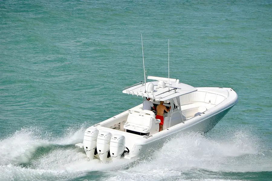 White boat speeds across the bay