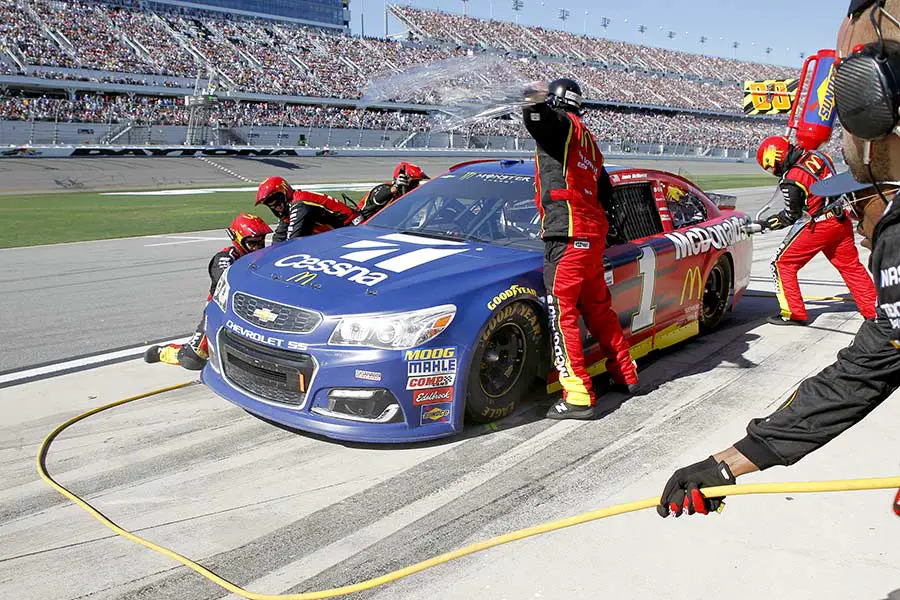 Pit crew works on race car during pit stop at Daytona Speedway