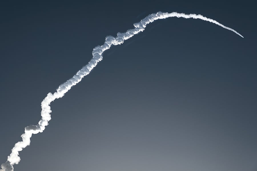 Curved rocket trajectory trail in the sky