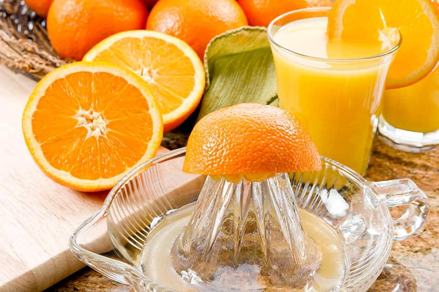 Orange halves and a glass of fresh orange juice