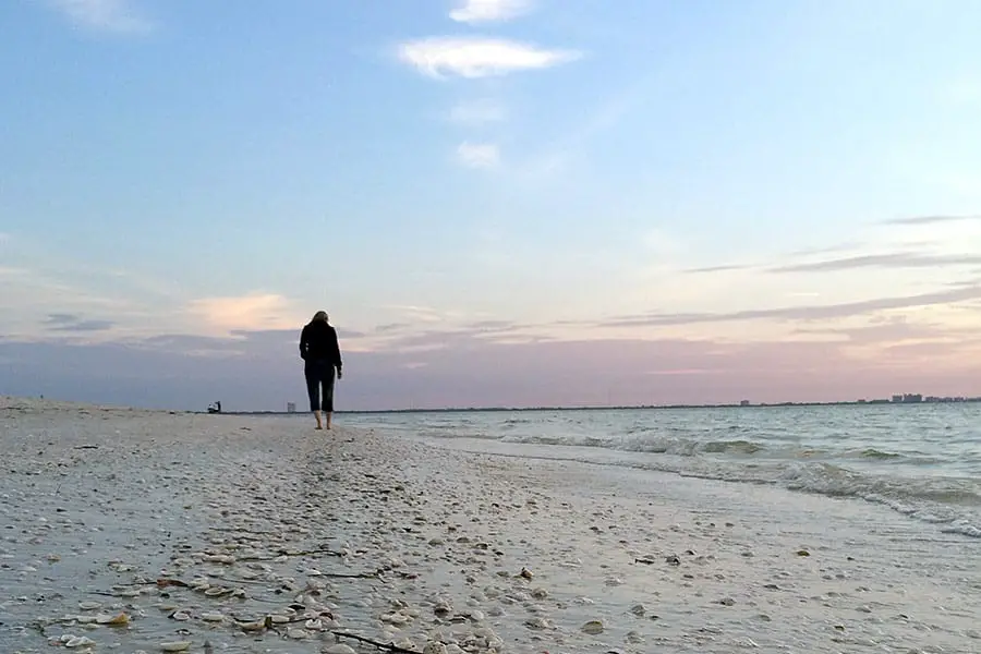 Man walking the beach looking for treasure