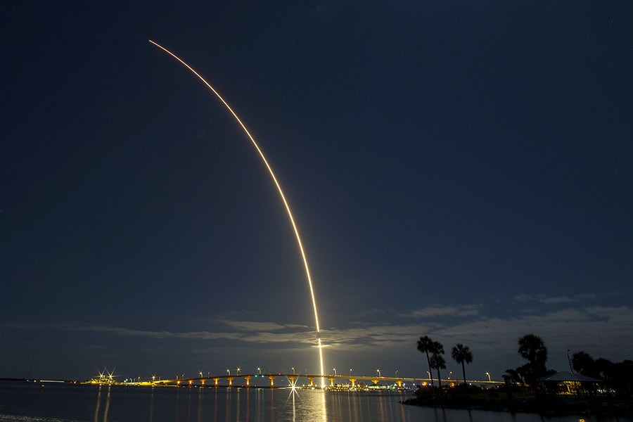 Nighttime rocket launch lights up bridge