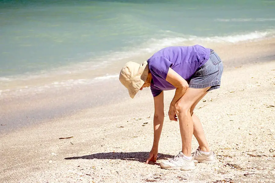 Woman searching the beach for sea shells
