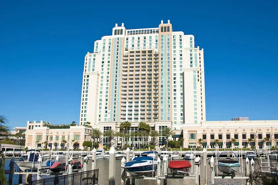 Boats docked at marina with hotel in background