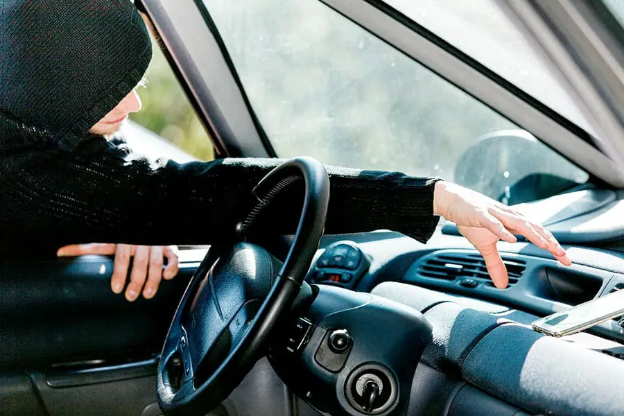 Thief stealing smartphone through car window