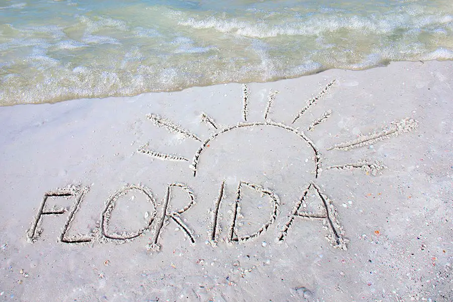 Sand writing on beach, Florida with sun drawn above name