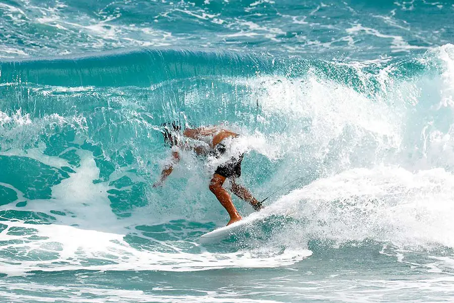 Water comes crashing down on surfer riding wave