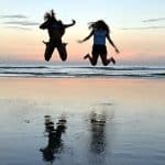 Two girls jumping on beach