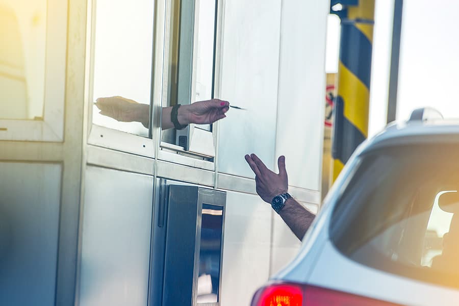 Man in car paying highway toll